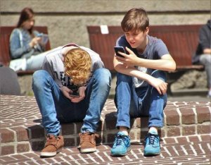 two boys in park on their phone